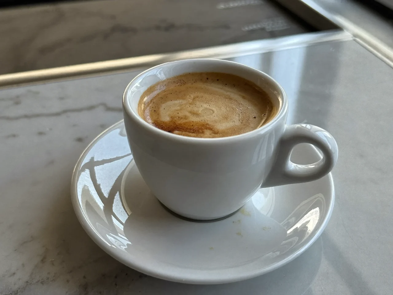Espresso con crema in tazza di ceramica bianca su piano di marmo